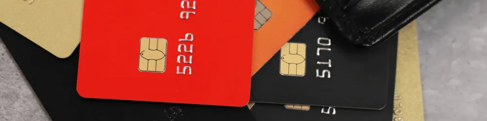 Pile of different credit cards on grey table, closeup